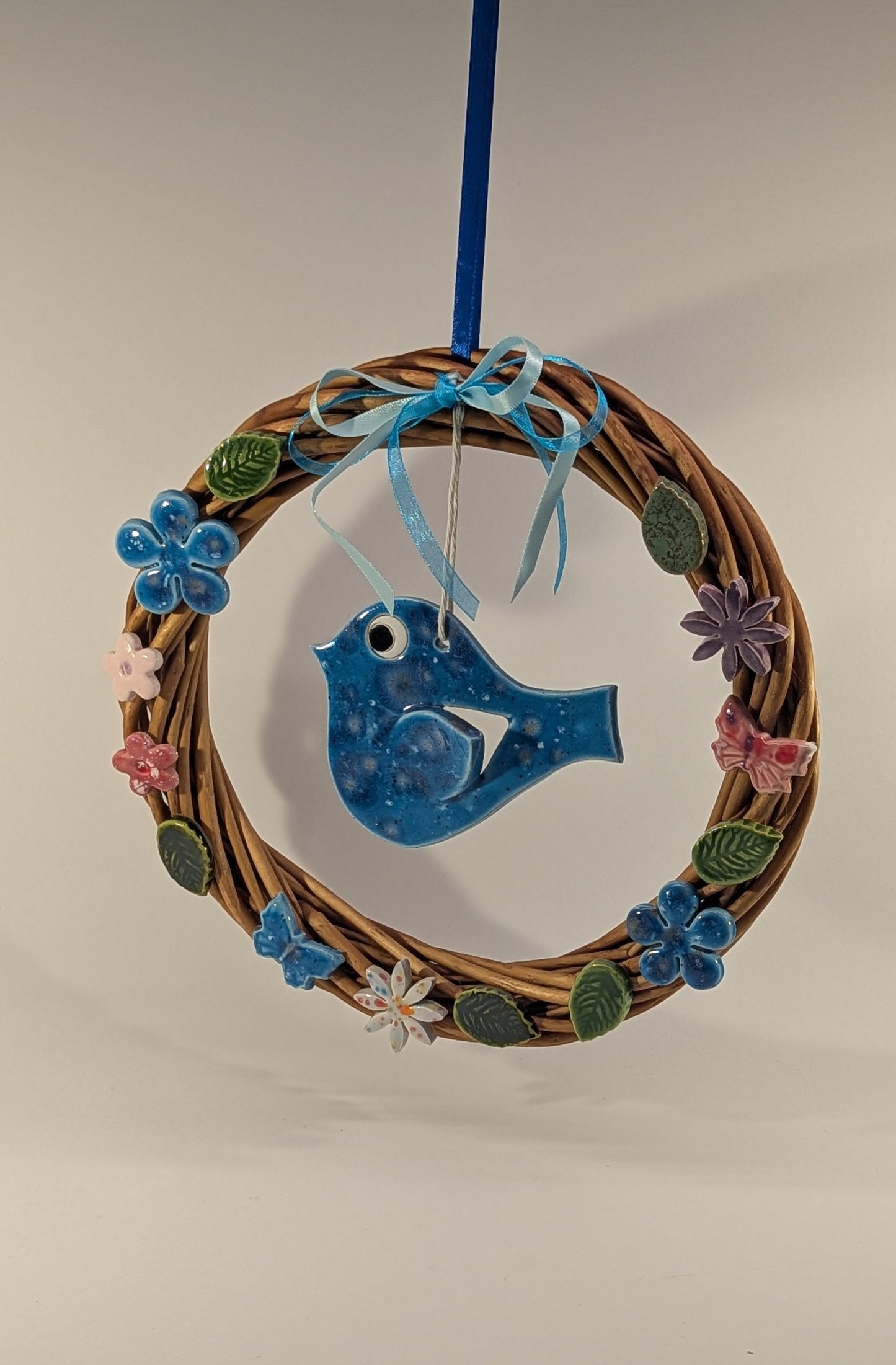 Ghirlanda di primavera con fiori e uccellino in ceramica artigianale