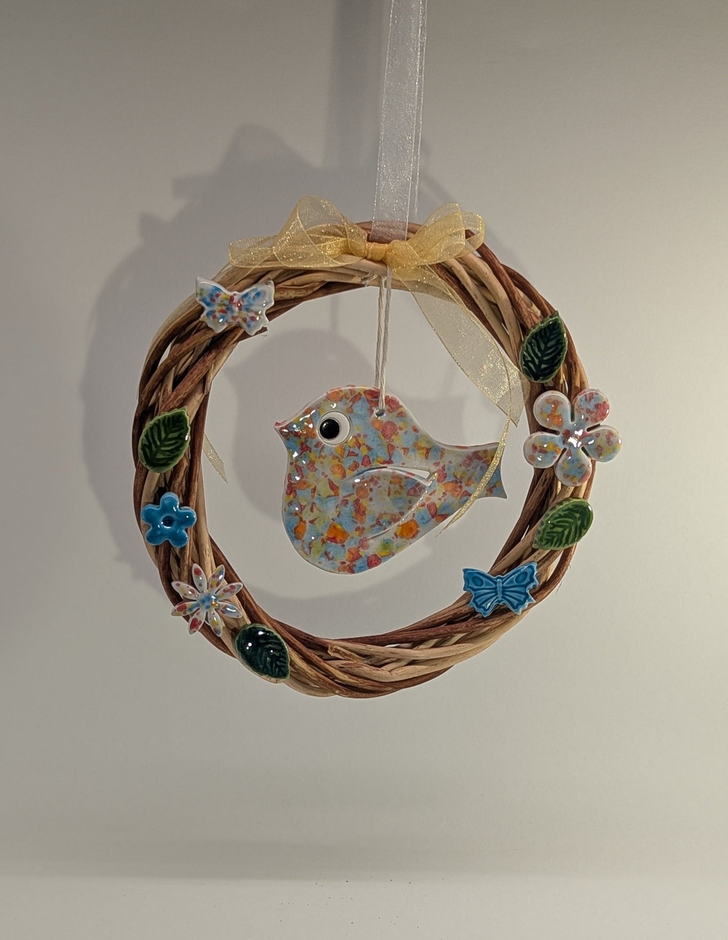 Ghirlanda di primavera con fiori e uccellino in ceramica artigianale