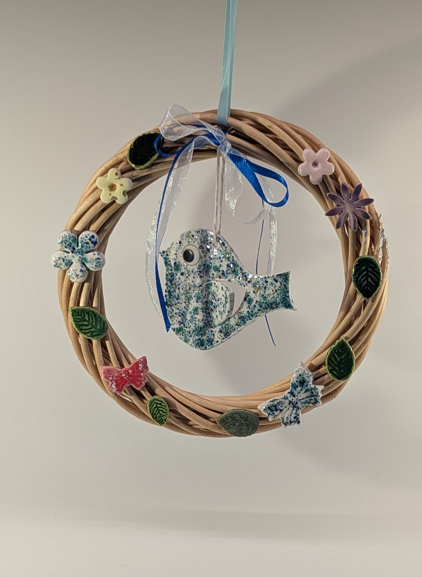 Ghirlanda di primavera con fiori e uccellino in ceramica artigianale